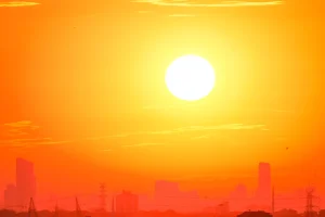 bright yellow sun over building cityscape